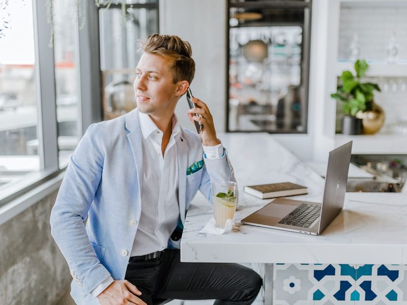 An agent taking a call at a counter with a laptop nearby