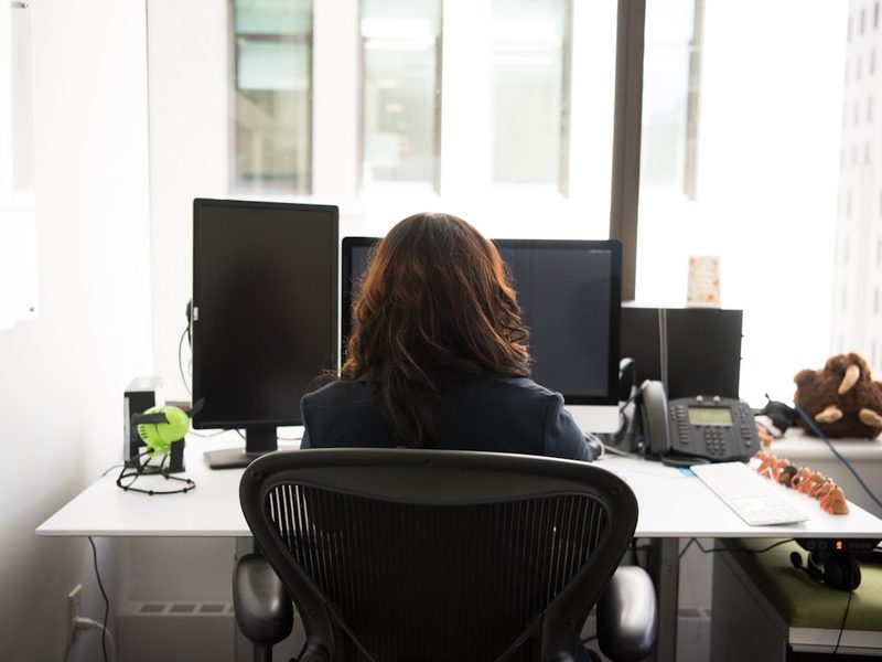 A marketer at a dual-monitor workstation